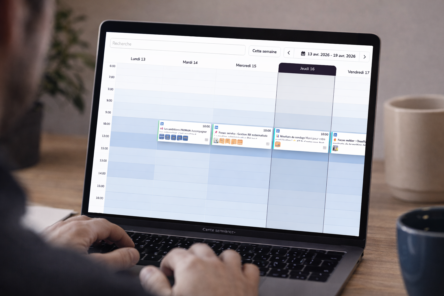 Personne consultant un agenda hebdomadaire sur ordinateur portable, planning professionnel affiché sur un bureau avec tasses à café