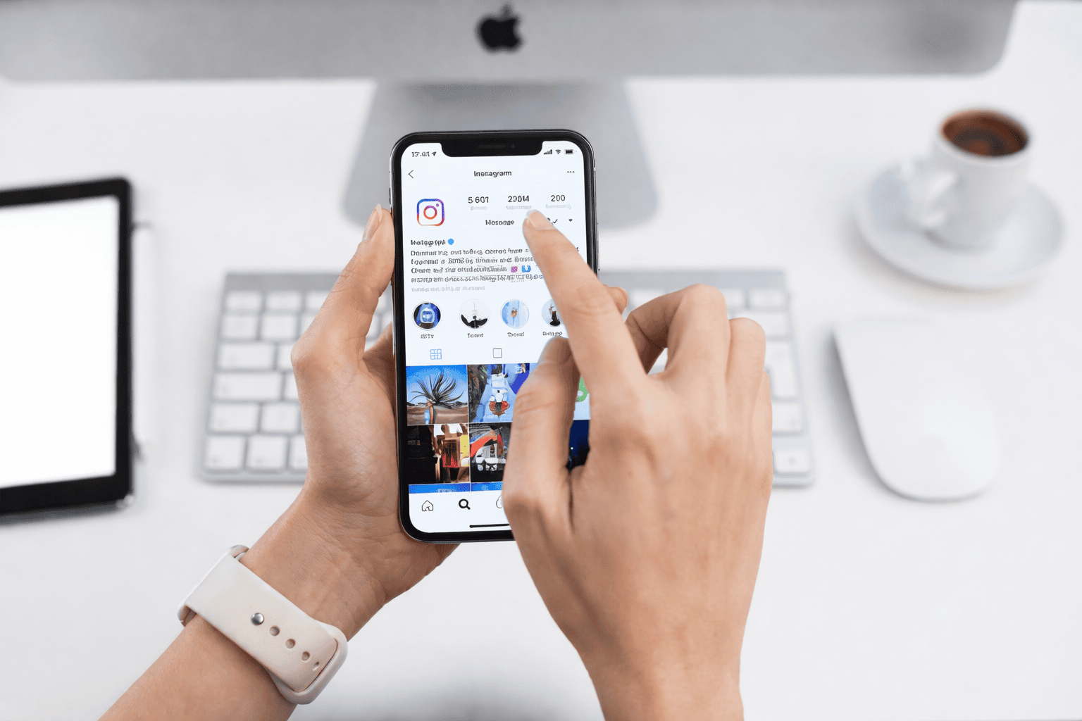 Main utilisant Instagram sur smartphone au bureau, consultant un profil de réseau social devant un poste de travail épuré