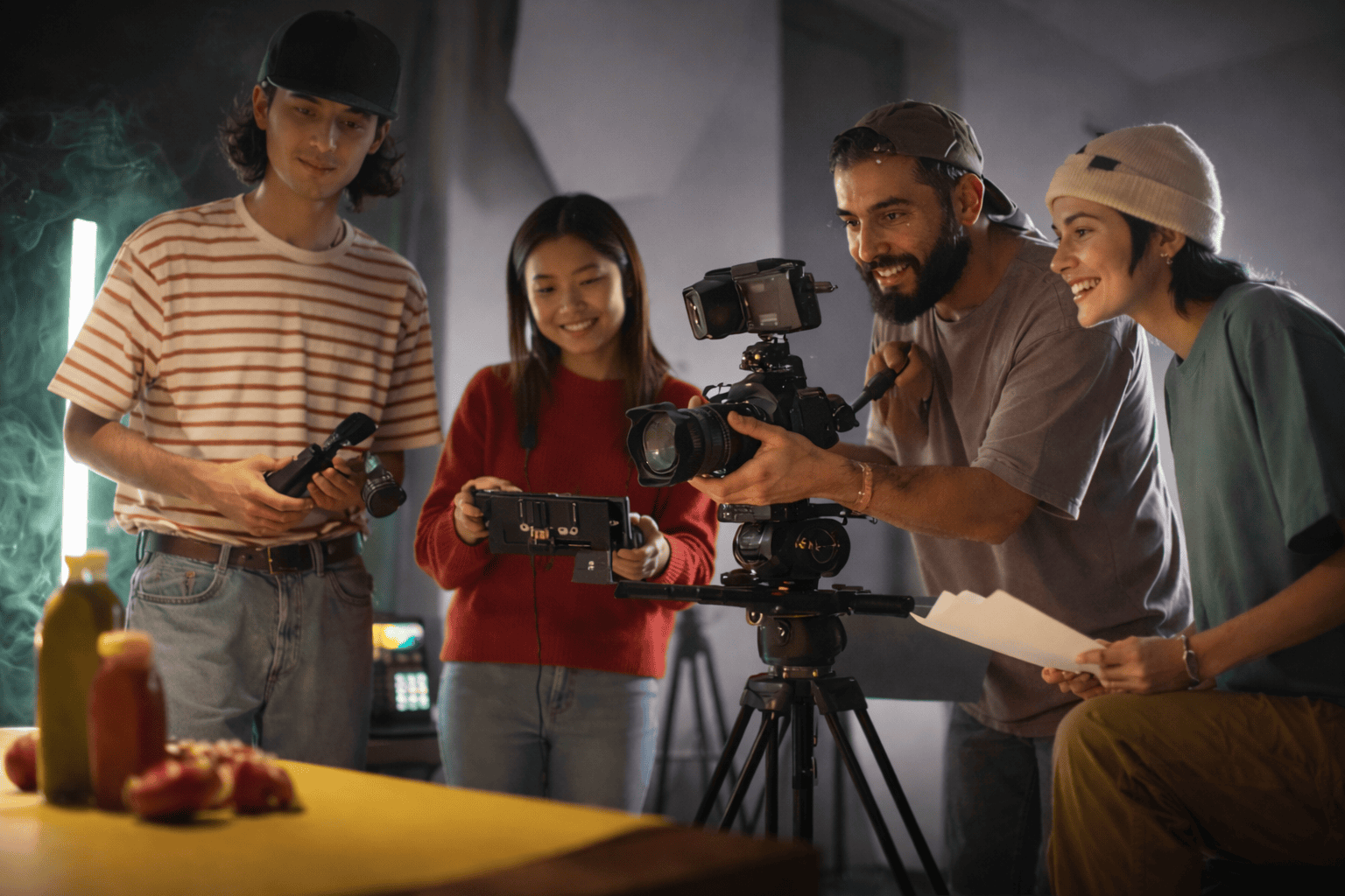 Équipe de tournage filmant une scène en studio avec caméra sur trépied, éclairage créatif et préparation audiovisuelle