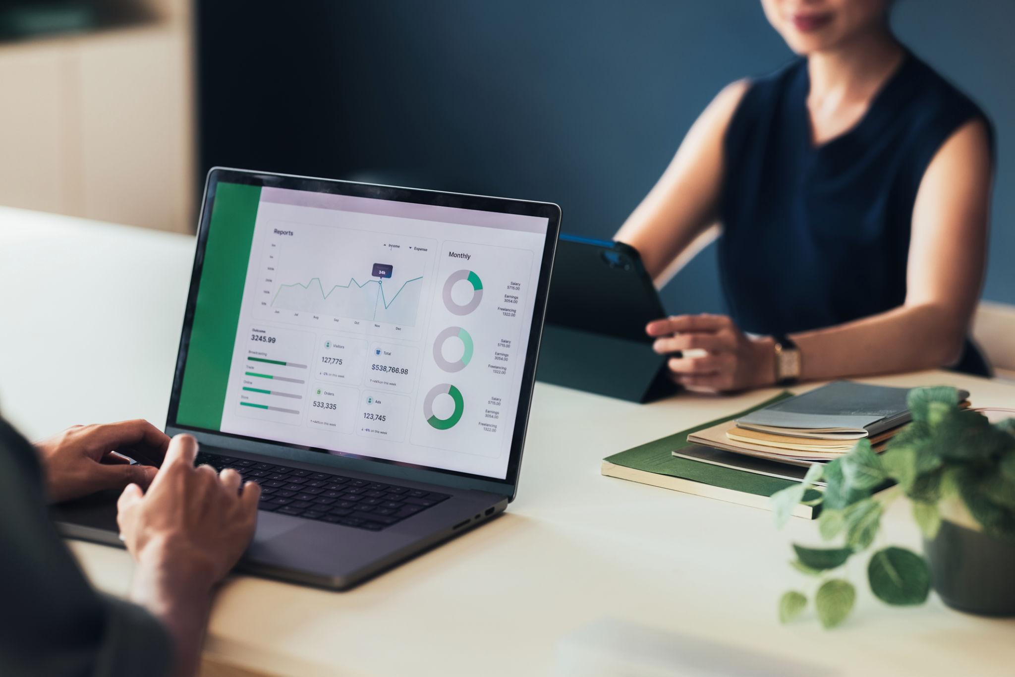 Personnes analysant des données sur un tableau de bord affiché sur un ordinateur portable et une tablette, avec graphiques et indicateurs de performance pour le suivi et l’optimisation des résultats